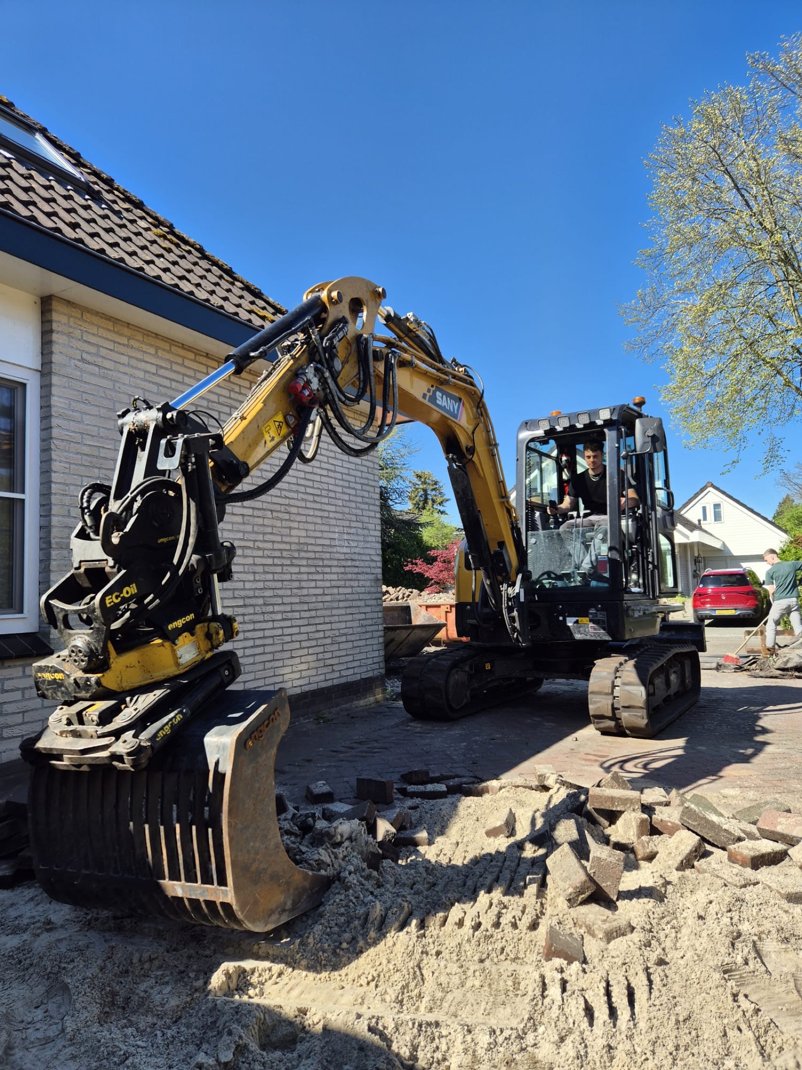 Graafmachine met breker die asfalt afbreekt